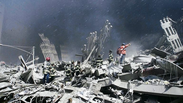 Rescue personnel look for victims in the ruins of the...