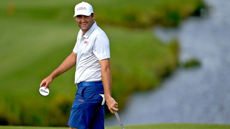 Scottie Scheffler, of the United States, smiles on the 11th...