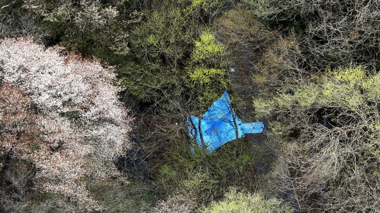 A plastic sheet covers the site where the dead bodies...