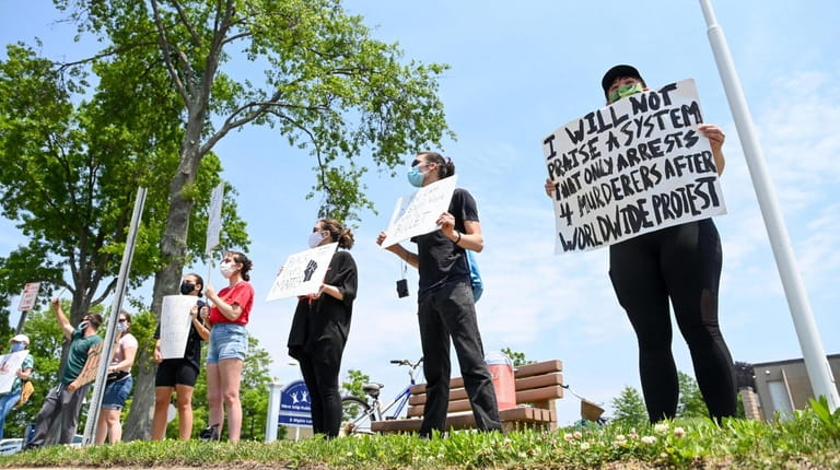 George Floyd protesters stand outside the West Islip Public Library...