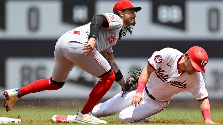 Cincinnati Reds second baseman Jonathan India, left, tags out Washington...