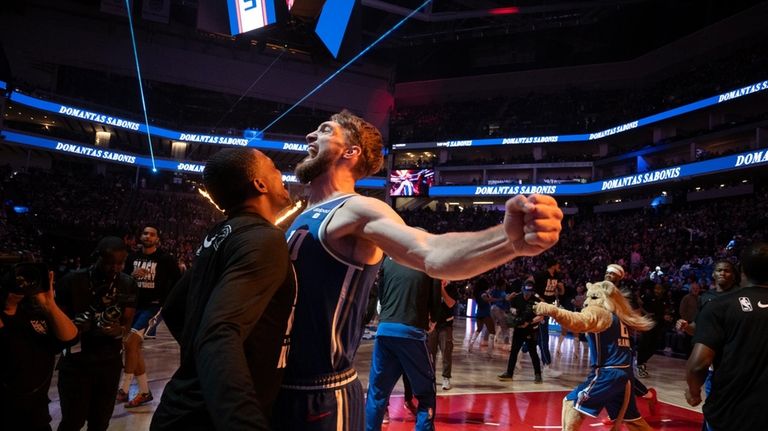 Sacramento Kings forward Domantas Sabonis, front right, bumps chests with...