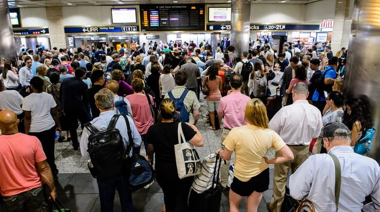 Passengers near the LIRR departures board in Penn Station June...