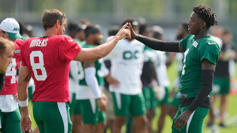 Jets cornerback Sauce Gardner, right, greets quarterback Aaron Rodgers during practice...