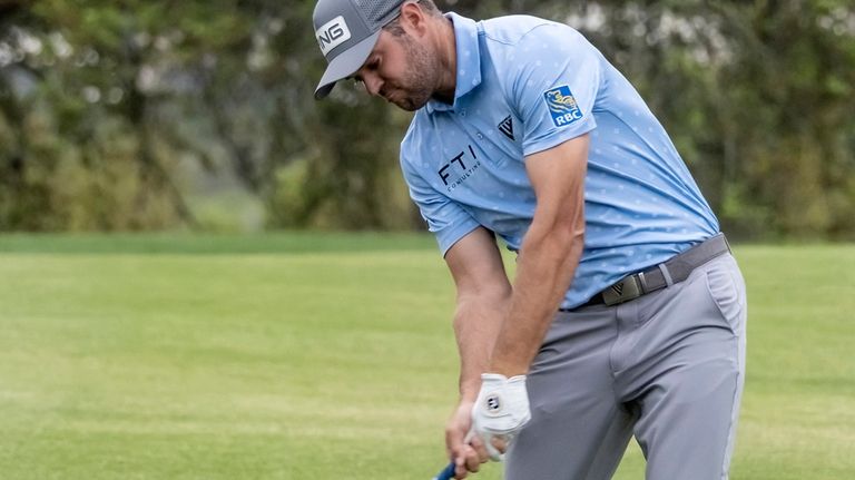 Corey Conners hits from the fairway on the 18th hole...