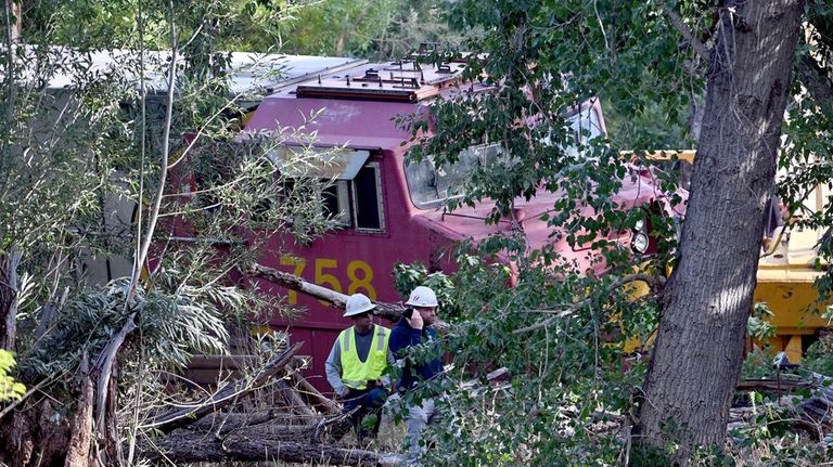 Clean-up workers toil to clear debris at the derailment site...