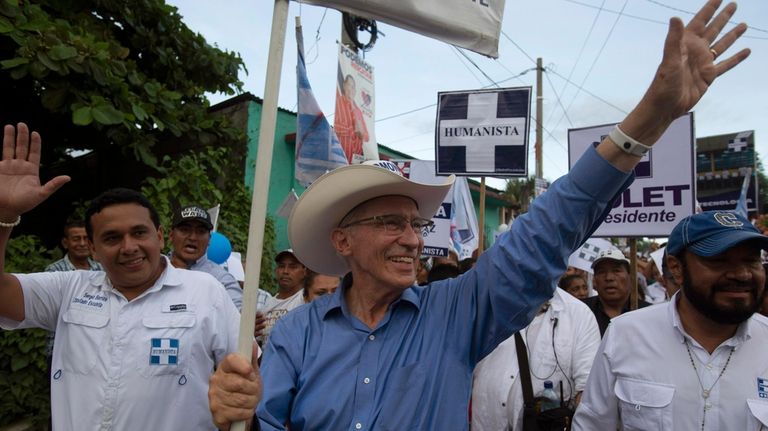 Presidential candidate Edmond Mulet waves to residents as he campaigns...