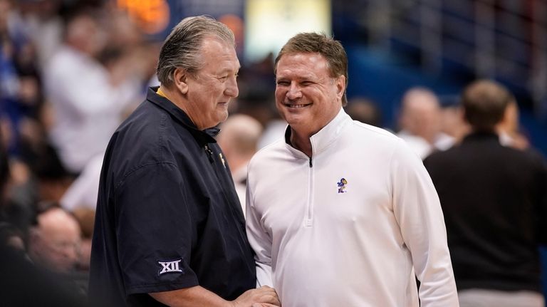 West Virginia head coach Bob Huggins, left, and Kansas head...