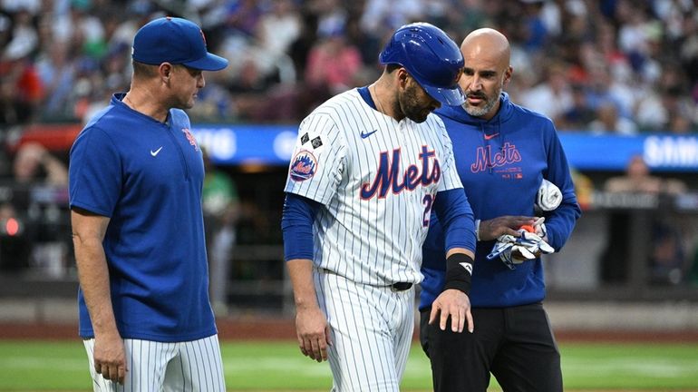 Mets manager Carlos Mendoza and a trainer check on J.D....