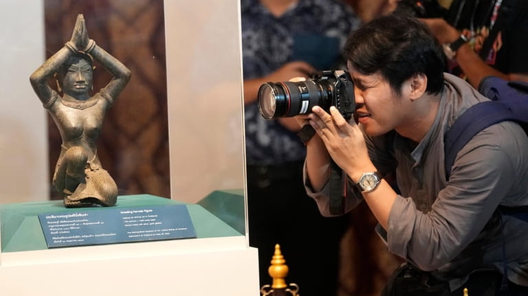 Thai photographer takes a picture of the ancient bronze kneeling...