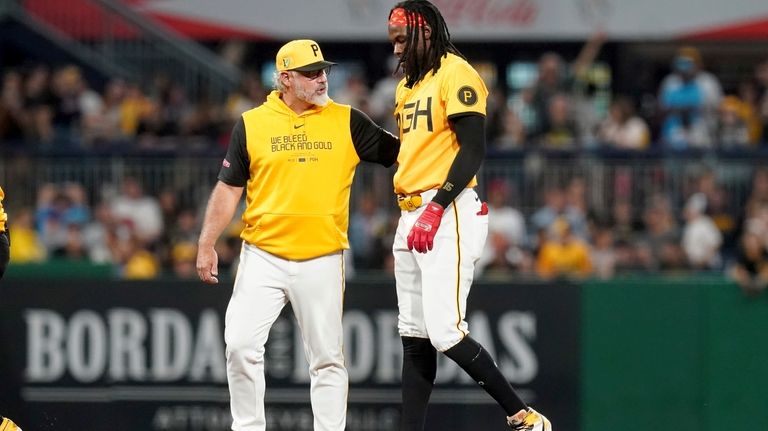 Pittsburgh Pirates' Oneil Cruz, right, leaves the field with manager...