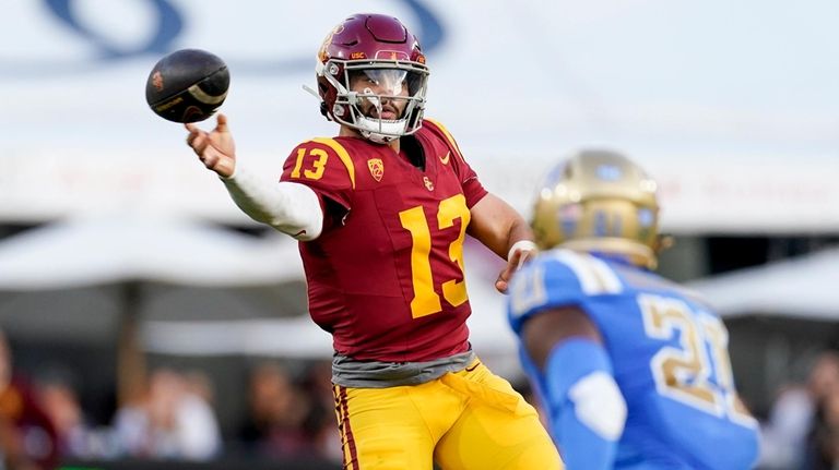 Southern California quarterback Caleb Williams, left, throws a pass as...