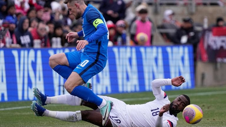 United States defender Shaq Moore (18) is tripped up as...