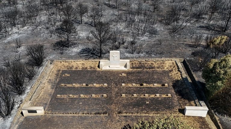 An aerial shot shows part of the extinguished wildfire area...