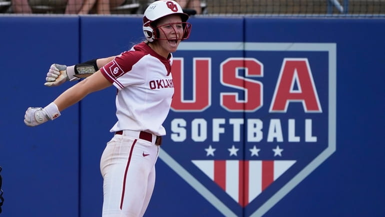 Oklahoma's Jana Johns celebrates after scoring in the fifth inning...