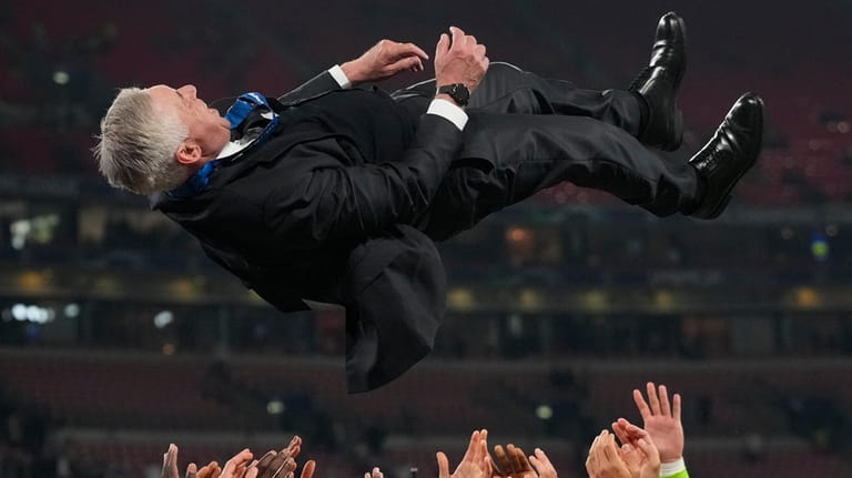 Players throw Real Madrid's head coach Carlo Ancelotti in the...