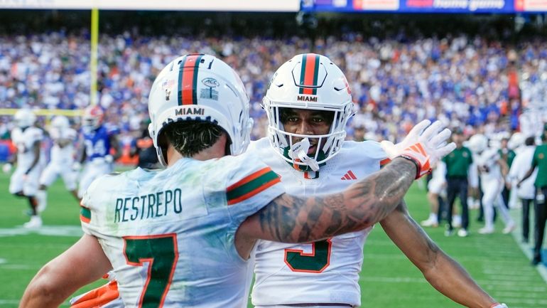 Miami wide receiver Jacolby George, right, celebrates after his 23-yard...