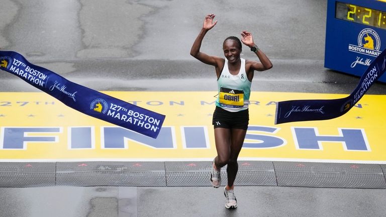 Hellen Obiri, of Kenya, breaks the tape at the finish...