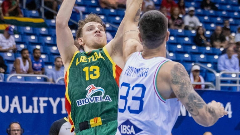 Lithuania's Rokas Jokubaitis, left, shoots over Italy's Achille Polonara, during...