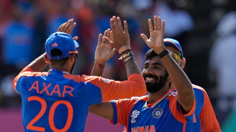 India's Jasprit Bumrah, right, celebrates with teammate Axar Patel after...