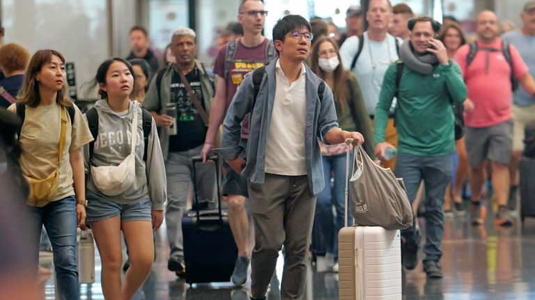 Travelers pass through Salt Lake City International Airport on July...