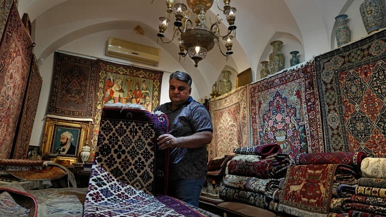 Iranian carpet shop owner Ali Faez works at his shop...