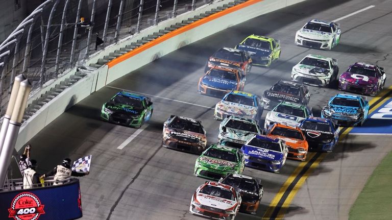 Harrison Burton (21) takes the checkered flag to win a...