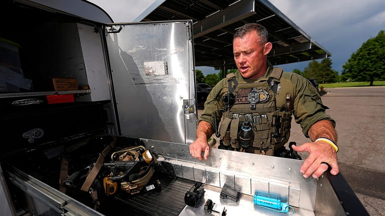 Denver Police Department Sgt. Justin Dodge surveys his gear Wednesday,...
