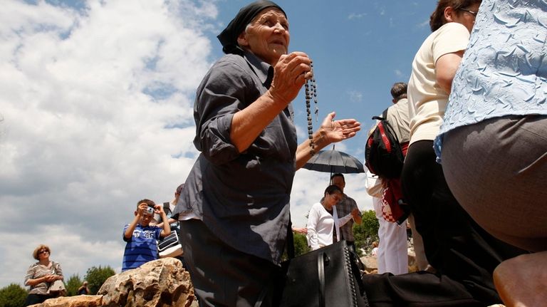 Pilgrims prays at the "Hill of Apparitions" in the southern-Bosnian...