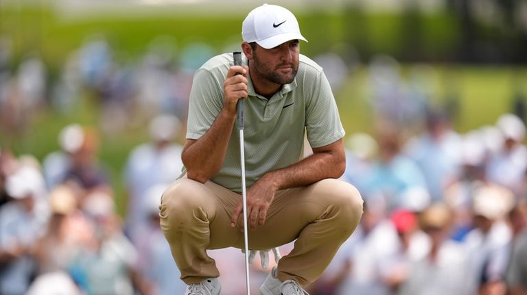 Scottie Scheffler lines up a putt on the third green...