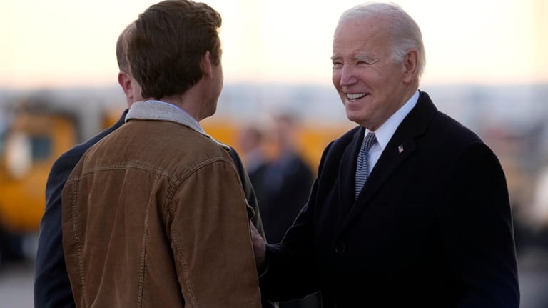 President Joe Biden greets Colorado Gov. Jared Polis, and Denver...