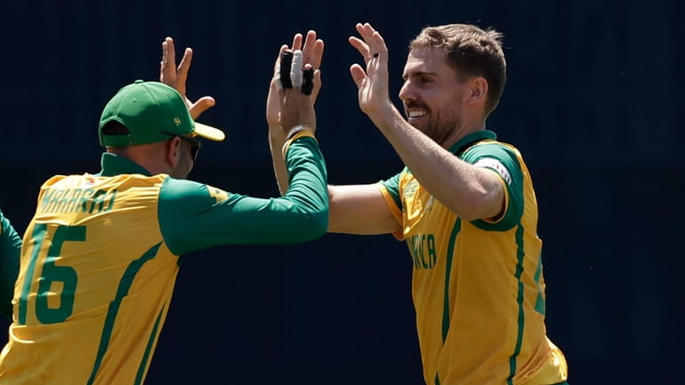 South Africa's Anrich Nortje, right, celebrates with teammate Keshav Maharaj...