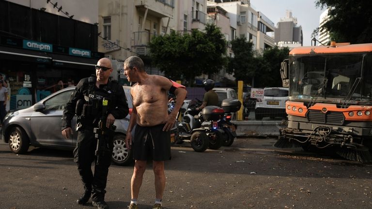 A runner stops to speak with Israeli police investigating the...