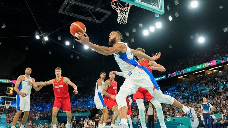 Rudy Gobert (27), of France drives past Germany during a...