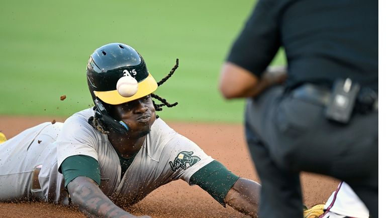 Oakland Athletics' Lawrence Butler, left, is hit on the helmet...