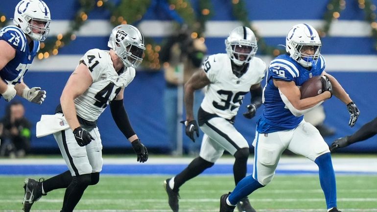 Indianapolis Colts running back Jonathan Taylor, right, runs during the...