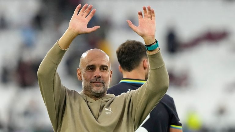 Manchester City's head coach Pep Guardiola waves supporters at the...