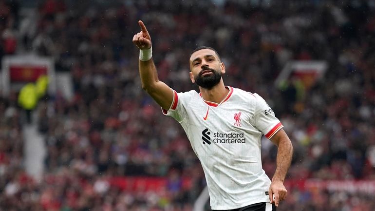 Liverpool's Mohamed Salah celebrates after scoring his side's third goal...