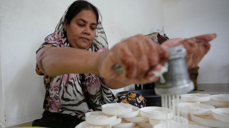 Fathima Shiyama, 48, prepares local delicacies at home, to be...