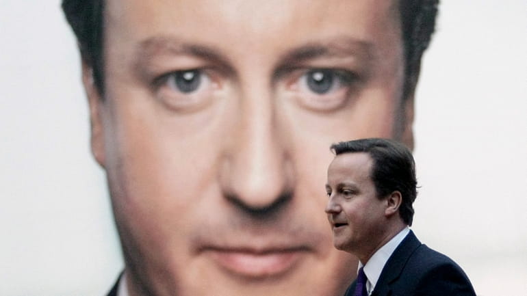 The leader of Britain's opposition Conservative party David Cameron walks...
