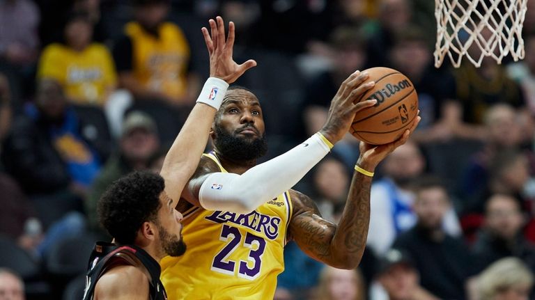 Los Angeles Lakers forward LeBron James shoots next to Portland...