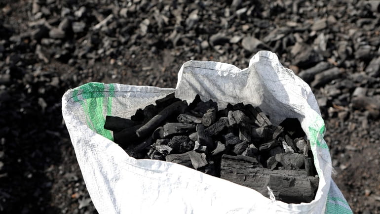 A sack of charcoal is filled in Gulu, Uganda on...