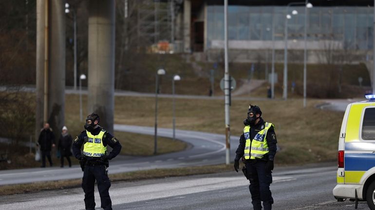 Police officers with gas masks stand guard near the Security...