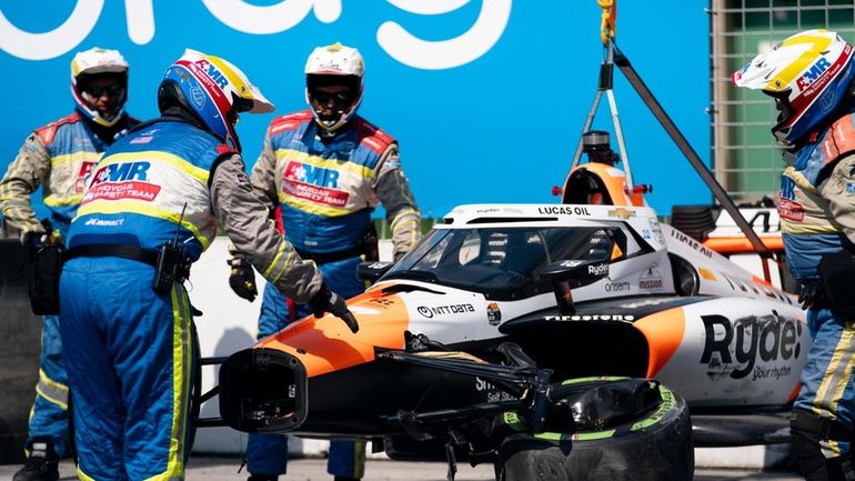 The car of Alexander Rossi is removed from the track...