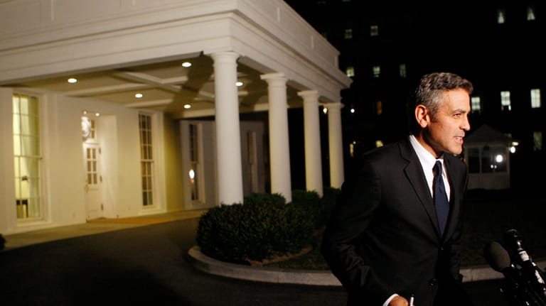 Actor George Clooney speaks to the media following a meeting...