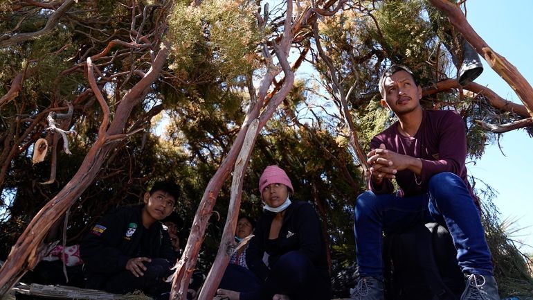 A group of asylum-seekers from Ecuador wait in a makeshift...