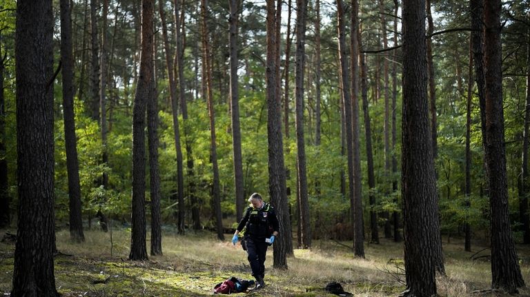 Federal Police officer Frank Malack looks at the belongings of...