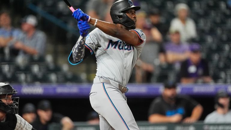 Miami Marlins' Jesus Sanchez follows the flight of his three-run...