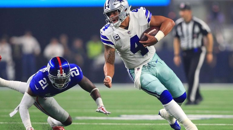 Dak Prescott evades Landon Collins on a scramble on Sept....