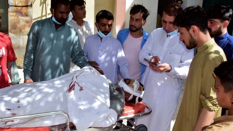 Relatives gather around a body of a passenger, killed by...